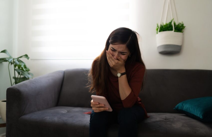 Latin woman crying because of a sad text message