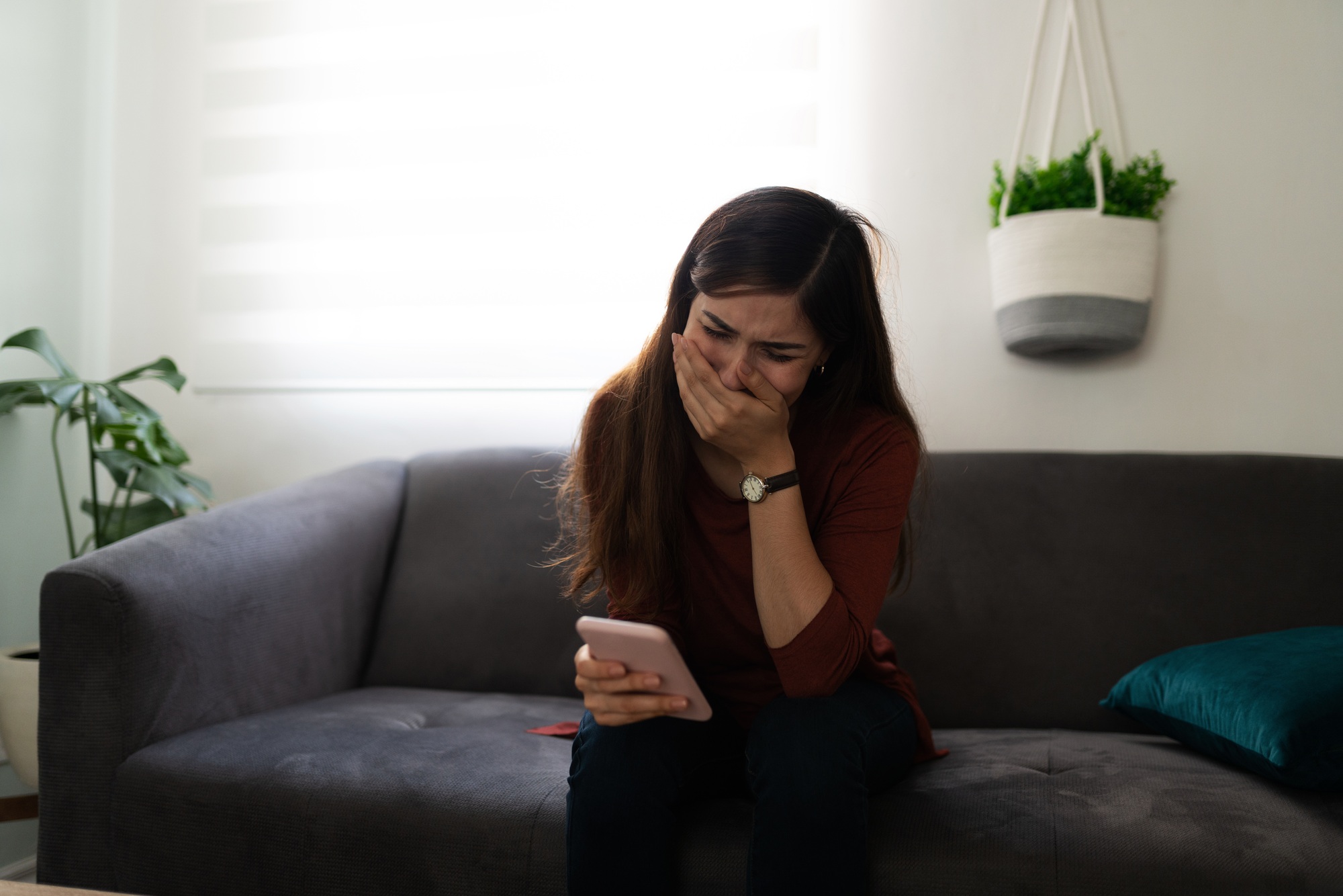 Latin woman crying because of a sad text message