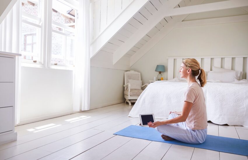 Woman With Digital Tablet Using Meditation App In Bedroom
