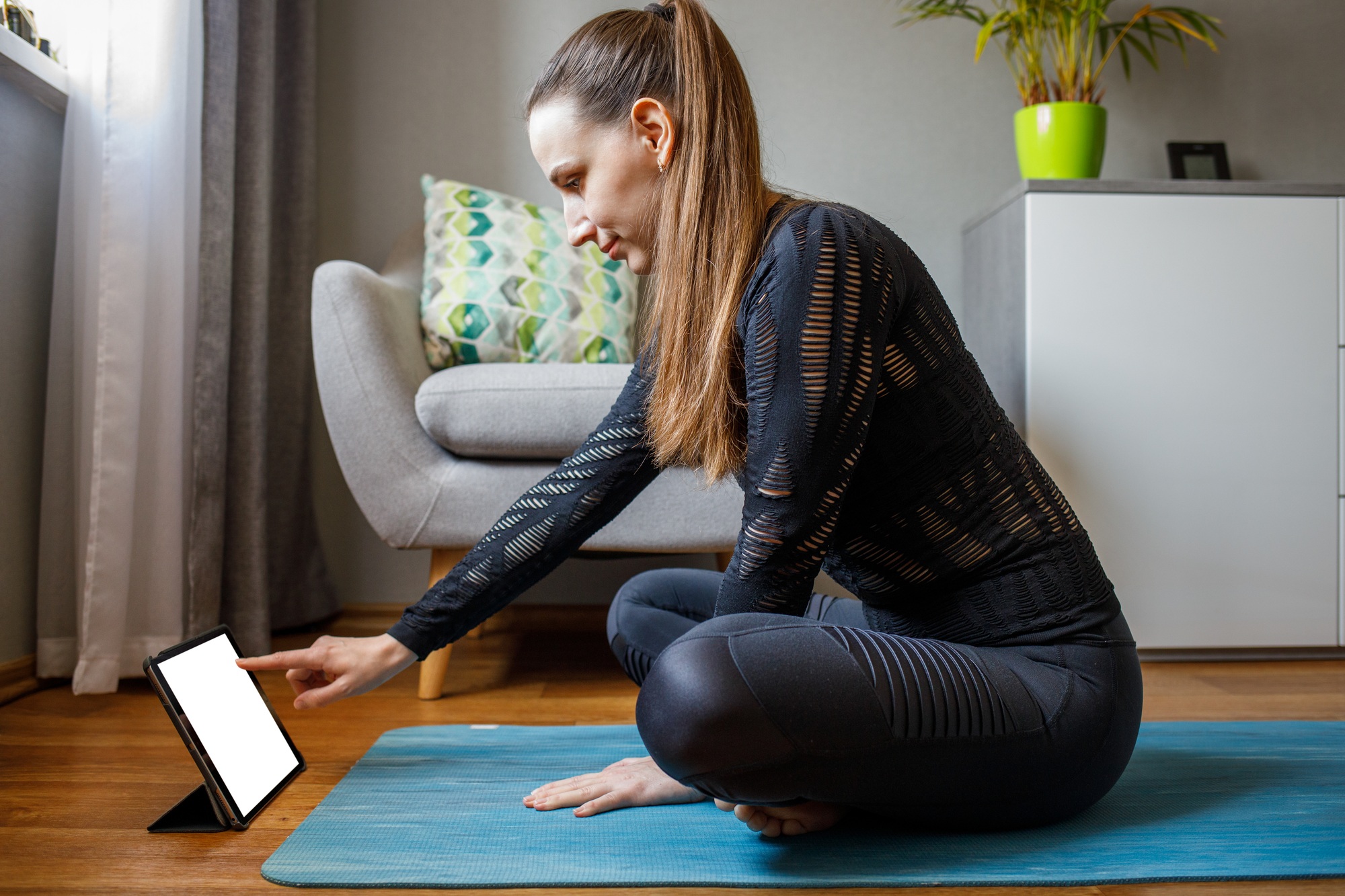 Young woman starting her online yoga class at home